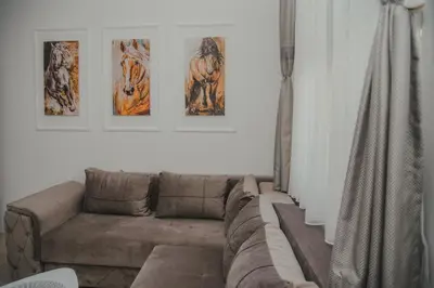 a living room with a couch and three pictures on the wall at Jes Apartments in Leskovac