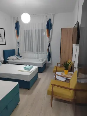 a living room with two beds and a chair at Jes Apartments in Leskovac