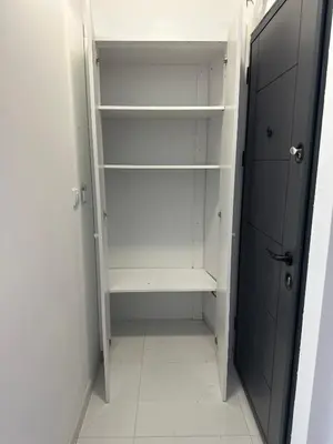 a walk in closet with white shelves and a door at 407 Elegant in Vrnjačka Banja
