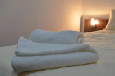 a stack of towels sitting on top of a bed at Garni Hotel Lion in Jagodina