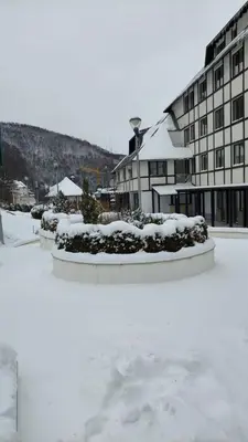 a courtyard covered in snow in front of a building at Apartman 22, Brzeće Centar in Mramor