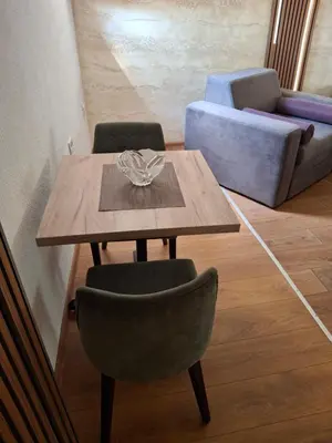 a wooden table and chairs in a living room at A&S Apartments Nis in Niš