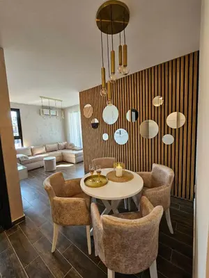 a living room with a table and some chairs at Apartman KING CENTAR in Vrnjačka Banja