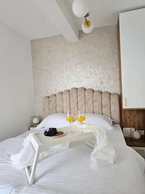a bedroom with a bed with two glasses of wine at Apartman KING CENTAR in Vrnjačka Banja