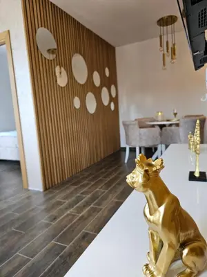 a gold dog statue sitting on a table in a living room at Apartman KING CENTAR in Vrnjačka Banja