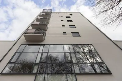 a tall white building with windows on the side at Harmony Studio Suite in Jagodina