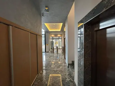 a lobby with a hallway with marble floors and walls at Harmony Studio Suite in Jagodina