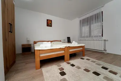 a bedroom with a bed in a white room at Apartmani Smiljković90 in Aleksandrovac
