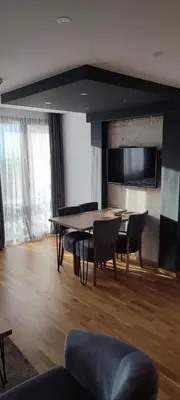 a living room with a table and chairs and a television at Golden Hour in Kopaonik