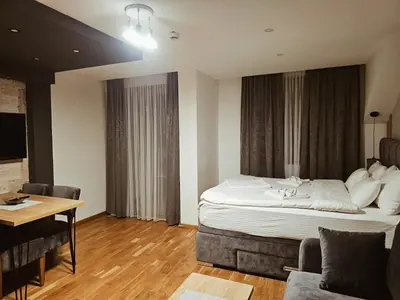 a hotel room with a large bed and a table at Golden Hour in Kopaonik