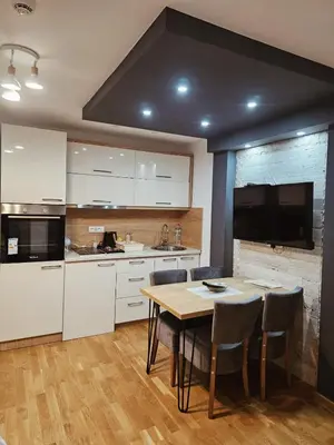 a kitchen with a table and chairs and a television at Golden Hour in Kopaonik