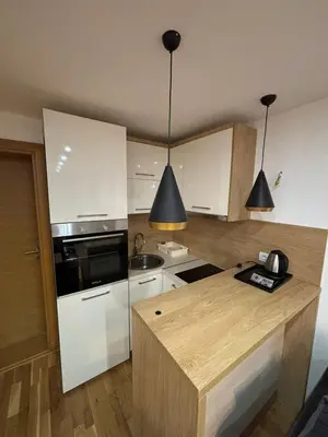 a kitchen with white cabinets and a wooden counter top at Golden Hour in Kopaonik