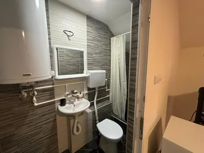 a small bathroom with a toilet and a sink at Apartmani Andjeo in Kraljevo