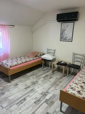 a room with two beds and two chairs at Apartmani Andjeo in Kraljevo