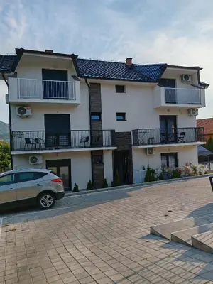 a house with a car parked in front of it at Apartman sa pogledom na Ozren in Soko Banja