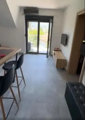 a living room with chairs and a table and a window at Apartman sa pogledom na Ozren in Soko Banja
