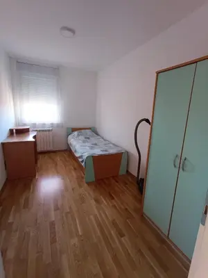 a small bedroom with a bed and a mirror at Luksuzni Apartman Ema in Pirot