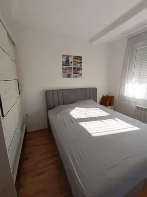 a bedroom with a bed in a room with a window at Luksuzni Apartman Ema in Pirot