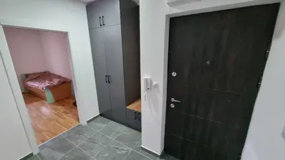 a bathroom with a black door and a bedroom at Luksuzni Apartman Ema in Pirot