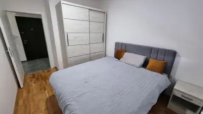 a bedroom with a large bed and a closet at Luksuzni Apartman Ema in Pirot
