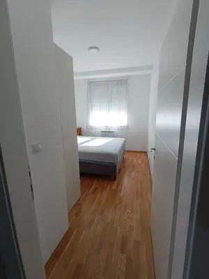 a small bedroom with a bed and a window at Luksuzni Apartman Ema in Pirot
