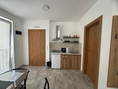 a small kitchen with a table and a door at Vas Dom in Soko Banja