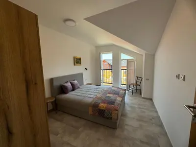a bedroom with a bed and a large window at Vas Dom in Soko Banja