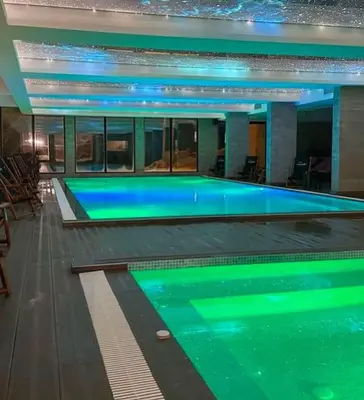 a large swimming pool with blue water in a building at Milmari L39 Kopaonik in Kopaonik