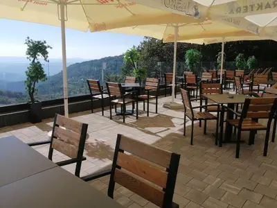a restaurant with tables and chairs and umbrellas at Husky N in Raška