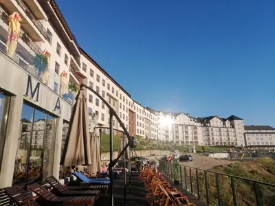 a hotel with chairs and umbrellas on a balcony at Husky N in Raška