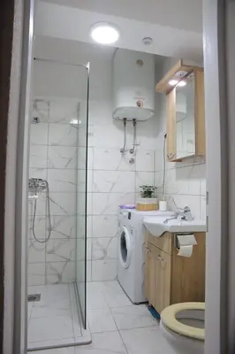 a bathroom with a shower and a washing machine at Stan na dan in Paraćin
