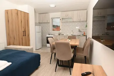 a kitchen and dining room with a table and chairs at Apartmani Timacum in Knjazevac.