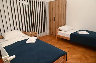 a small room with two beds and a window at Apartmani Timacum in Knjazevac.