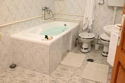 a bathroom with a tub and a toilet and a sink at Apartmani Timacum in Knjazevac.