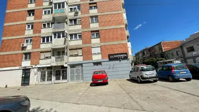 two cars parked in a parking lot in front of a building at Stan na Dan - Centar - Besplatan parking in Niš