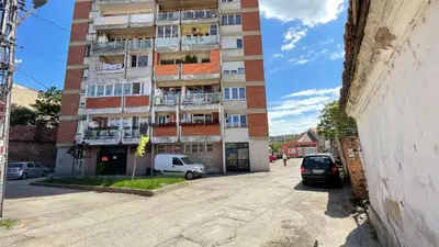 a tall building with cars parked in front of it at Stan na Dan - Centar - Besplatan parking in Niš