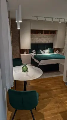 a room with two beds and a table and a bed at Apartman Đorđe in Vrnjačka Banja