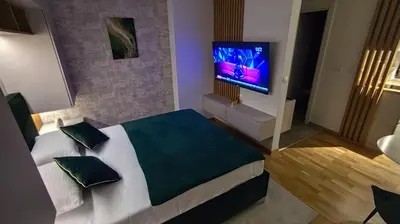 a bedroom with a bed and a flat screen tv at Apartman Đorđe in Vrnjačka Banja