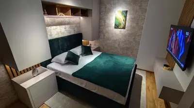 a small bedroom with a bed and a tv at Apartman Đorđe in Vrnjačka Banja
