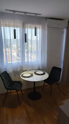 a table and two chairs in a room with a window at Apartman Đorđe in Vrnjačka Banja