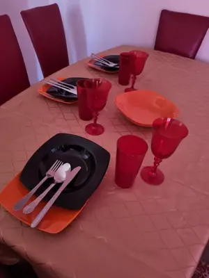 a table with red plates and red glasses on it at Ana LUX in Dobrosin