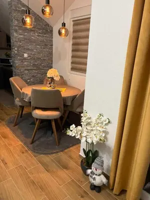 a dining room with a table and chairs and flowers at SOUL Apartman in Soko Banja