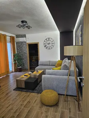 a living room with a couch and a clock on the wall at SOUL Apartman in Soko Banja