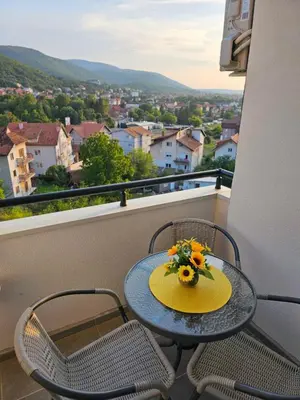 a table and chairs on a balcony with a view at SOUL Apartman in Soko Banja