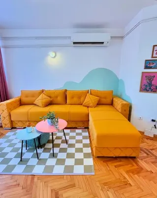 a living room with a yellow couch and a table at Happy Place Apartment Pirot in Pirot