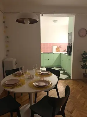 a table with plates and wine glasses on it at Happy Place Apartment Pirot in Pirot