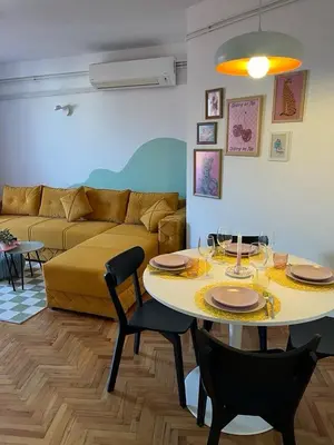 a living room with a table and a couch at Happy Place Apartment Pirot in Pirot