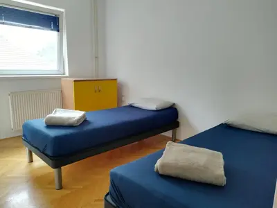 two twin beds in a room with a window at Aqua 11 big apartment in Jagodina