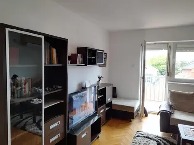 a living room with a tv and a entertainment center at Aqua 11 big apartment in Jagodina