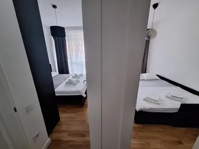 a small room with two beds and a mirror at Brooklyn88 Apartment in Niš